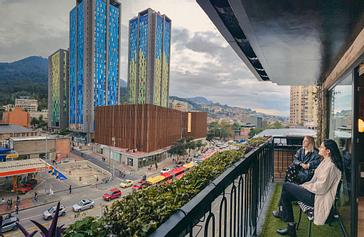 Viajero Hostels | Viajero Bogotá | Amigas disfrutando de la vista a las montañas bogotanas y monserrate en el balcón de su habitación en el Hostal Viajero en el centro
