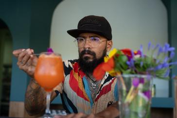 Viajero Hostels | Viajero Guatapé Hostel   | Bartender en una experiencia de cocteleria sostenible en el bar de Viajero Hostels Guatapé haciendo un Aperol Spritz