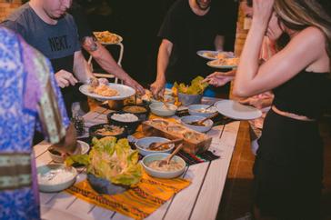 Viajero Hostels | Viajero Sayulita | Group of people serving themselves food from a buffet full of traditional Mexican food at Viajero Sayulita.