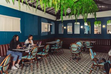 Viajero Hostels | Viajero Bogotá | Espacio de coworking con sofas y mesas invidivuales, toma corrientes y espejos en colores azules y con wifi gratis