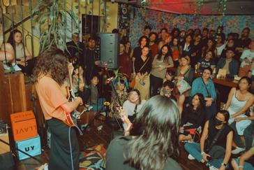 Viajero Hostels | Viajero Bogotá | Briela Ojeda tocando a un publico en vivo durante la fiesta de aniversario de Viajero Hostels Bogotá, abierto al público