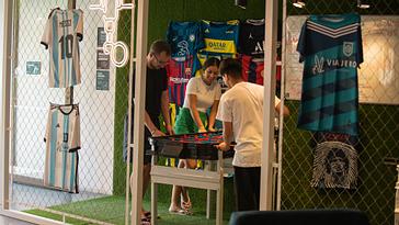 Viajero Hostels | Viajero Buenos Aires | A couple playing against a person at a foosball table in the games area at Viajero Buenos Aires.
