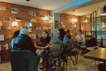 Viajero Hostels | Viajero Bogotá | Huéspedes en la sala social y de tv en Viajero hostels Bogotá, con libros para intercambiar y vista al exterior.