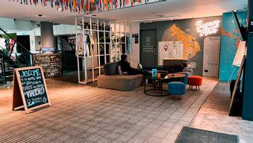 Viajero Hostels | Viajero Buenos Aires | Lobby de Viajero Hostels Buenos Aires con letreros de bienvenida, sofás cómodos y un mural con el mapa de Buenos Aires pintado en la pared.