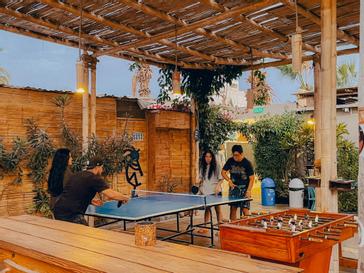 Viajero Hostels | Viajero Paracas Hostel | Four people playing outdoor ping pong at Viajero Kokopelli Paracas.