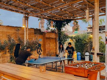 Viajero Hostels | Viajero Paracas Hostel | Four people playing outdoor ping pong at Viajero Kokopelli Paracas.
