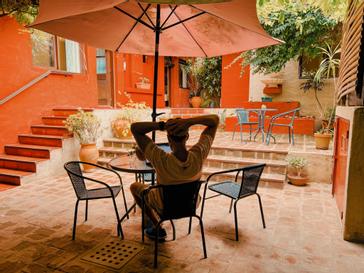 Viajero Hostels | Viajero Colonia Posada B&B | Persona relajándose durante una linda tarde en el espacio social ubicado en el patio de Viajero Posada 