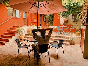 Viajero Hostels | Viajero Colonia Posada B&B | Persona relajándose durante una linda tarde en el espacio social ubicado en el patio de Viajero Posada