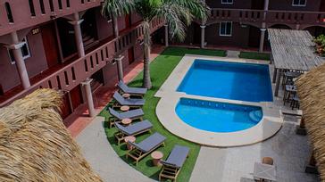 Viajero Hostels | Viajero Puerto Escondido | Vista desde la terraza de la zona de piscina y social con bar, restaurante, zona para sentarse y sillas de playa de Viajero Hostels Puerto Escondido