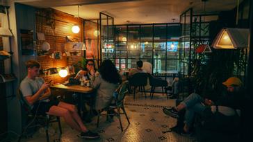 Viajero Hostels | Viajero Bogotá | Grupo de personas comiendo en el restaurante en el centro de Bogota, La Nevera. Con vista a la calle, televisión para transmitir eventos deportivos