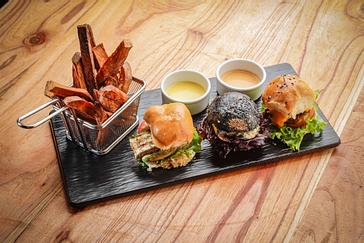 Viajero Hostels | Viajero Buenos Aires | Wooden tray with three hamburgers from the Casa Jaguar restaurant at Viajero Buenos Aires.