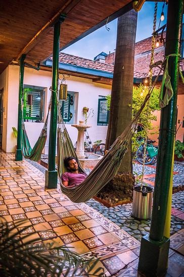 Viajero Hostels | Viajero Cali | Person sleeping in a hammock during the day at Viajero Cali.