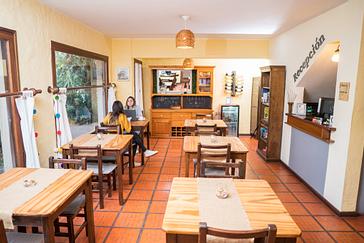 Viajero Hostels | Viajero Colonia Posada B&B | Amigas disfrutando la tarde mientras toman un café en la zona de restaurante y comedor del Hostal en Colonia, Uruguay con acceso a vinos y comidas