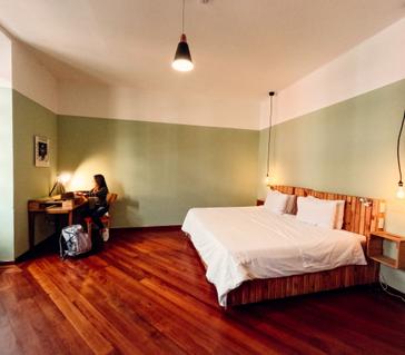 Viajero Hostels | Viajero Quito | Habitación privada tipo siut con cama doble, ventanas amplias y escritorio de viajero Hostel Quito