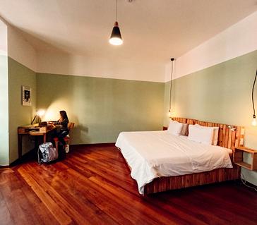 Viajero Hostels | Viajero Quito | Habitación privada tipo siut con cama doble, ventanas amplias y escritorio de viajero Hostel Quito