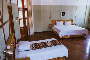 Viajero Hostels | Viajero Quito | Habitación privada con cama doble y cama sencilla para trees personas, toques rusticos y baño privado de viajero hostel Quito
