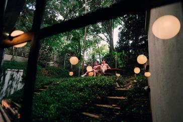 Viajero Hostels | Viajero Medellín | Pareja gozando del área natural sentados en una mesa exterior en hostal en Medellín con jardín Viajero hostels