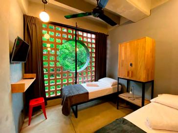 Viajero Hostels | Viajero Medellín | Habitación para dos personas con camas individuales, vista al montaña, televesión, ventilador de techo y espacio para guardar ropa