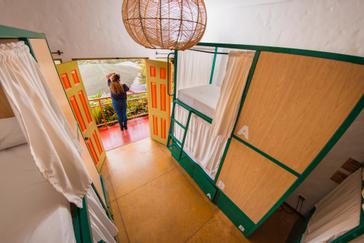 Viajero Hostels | Viajero Salento | Person standing in front of the entrance to a shared dormitory with bunk bed styles at Viajero Hostels Salento.