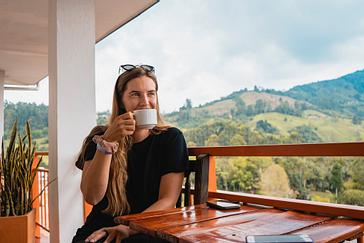 Viajero Hostels | Viajero Salento | Turista disfrutando un Café, sentado en un balcón de Viajero Hostels Salento