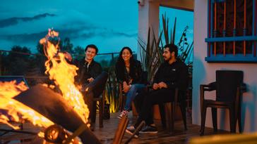 Viajero Hostels | Viajero Salento | Friends enjoying the campfire experience in the outdoor area at night at Viajero Hostel Salento.