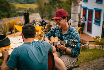 Viajero Hostels | Viajero Salento | Amigos compartiendo en el espacio común al aire libre de viajero hostels Salento mientras tocan guitarra