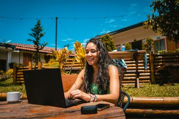 Viajero Hostels | Viajero Salento | Girl working in the open space during her stay in Salento at Viajero Hostels, while enjoying a coffee.