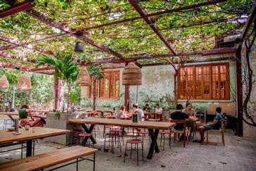 Viajero Hostels | Viajero Santa Marta | Turistas disfrutando de la hora del desayuno mientras conocen nuevas personas y comparten en el área del comedor decorado con vibes naturales y player