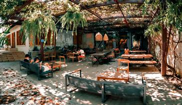 Viajero Hostels | Viajero Santa Marta | Viajeros en el espacio de comedor al aíre libre de viajero hostel Santa Marta realizando trabajo remoto en la perla de ámerica