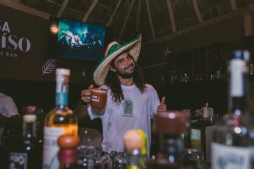 Viajero Hostels | Viajero Sayulita | Smiling tourist with a Mexican hat enjoying the bar at Casa Paraíso restaurant inside Viajero Hostels.