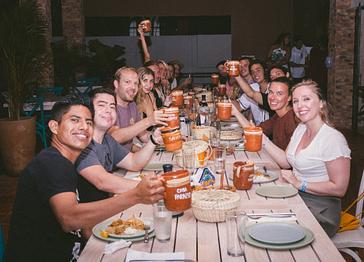 Viajero Hostels | Viajero Sayulita | Group of tourists enjoying a dinner with Mexican flavors and textures at the Casa Paraíso restaurant in Sayulita, near the city center.