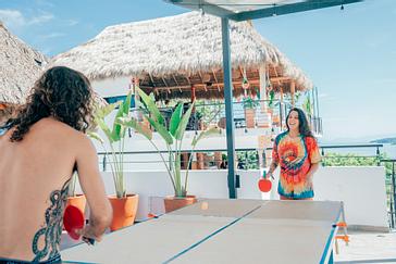 Viajero Hostels | Viajero Sayulita | Friends playing ping pong in the afternoon on the outdoor terrace at the hostel in Sayulita, close to the city center and the beach.
