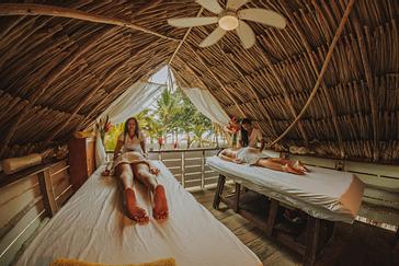Viajero Hostels | Viajero Tayrona | Pareja de turistas tomando un relajante masaje en viajero hostels Tayrona, conectando con la naturaleza y espacio de la playa caribeña de Colombia