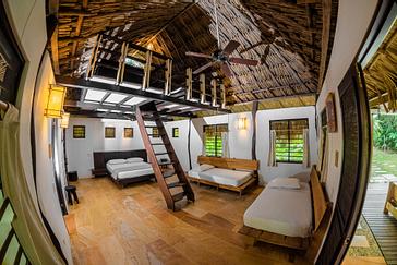 Viajero Hostels | Viajero Tayrona | Habitación privada para grupos estilo cabaña con un cama doble, y dos individuales, con ventiladores y pequeño segundo piso de viajero hostel Tayrona