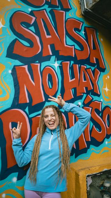 Viajero Hostels | Viajero Cali | Person taking a photo in front of a mural at Viajero Cali.