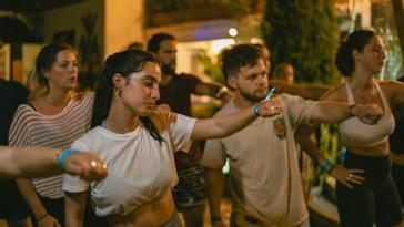 Viajero Hostels | Viajero Cali | Travelers in an outdoor salsa class during the night at Viajero Cali.